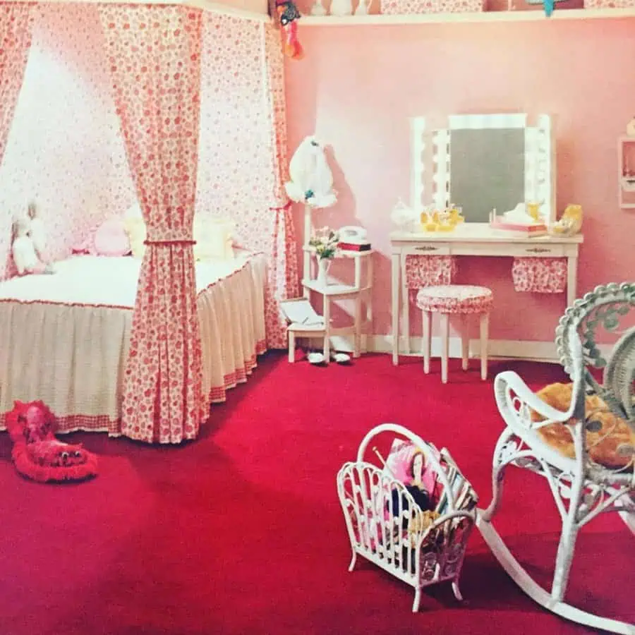 1960s pink bedroom with a canopy bed, vintage vanity, red carpet, and retro wicker furniture.