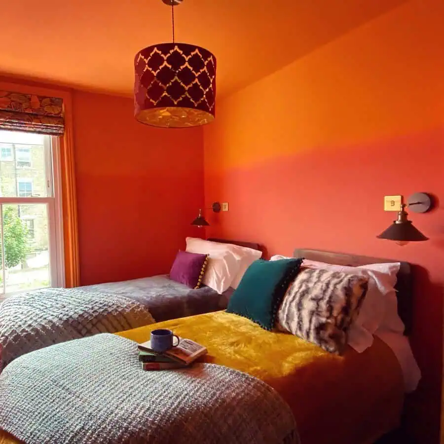 Bedroom with a blend of pastel and burnt orange tones, layered textures, and cozy, modern decor.