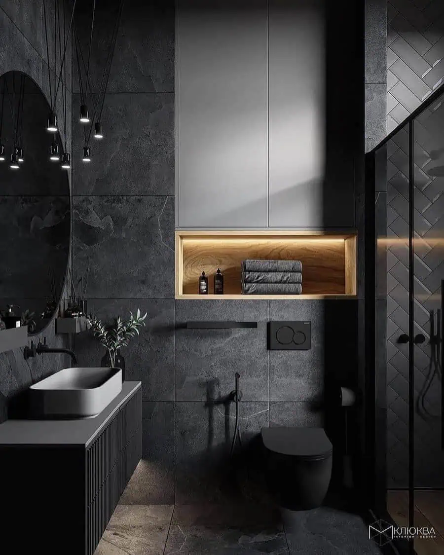 Modern black and grey bathroom with textured walls, floating vanity, and ambient lighting.