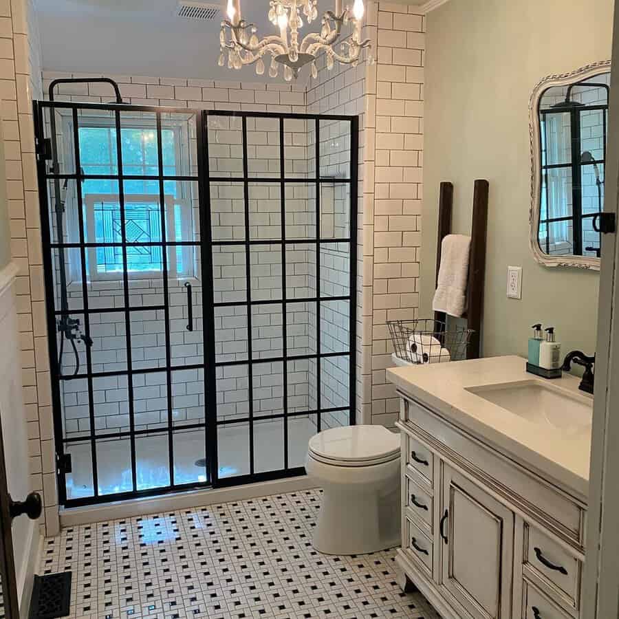 Black and white bathroom with geometric pattern tiles, subway walls, and a glass shower.