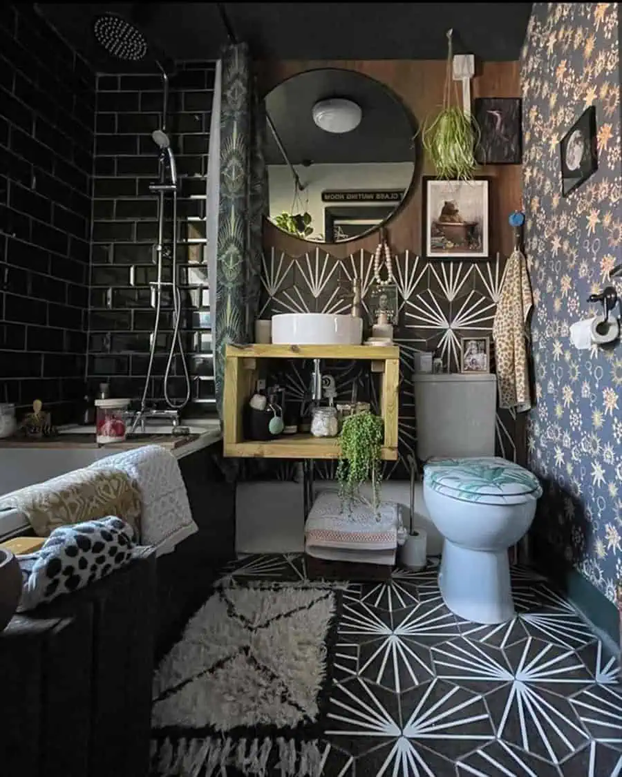 Eclectic black bathroom with boho decor, patterned tiles, and a wooden vanity.