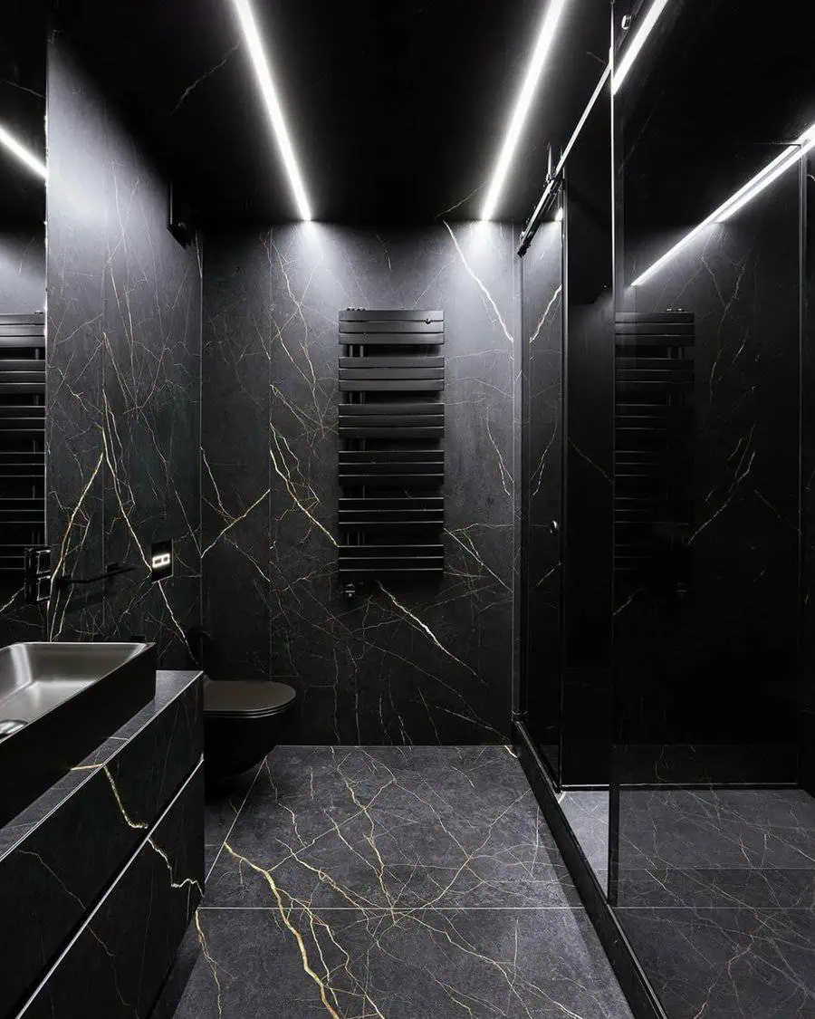 Modern black bathroom with gold-veined marble, sleek lighting, and a minimalist design.