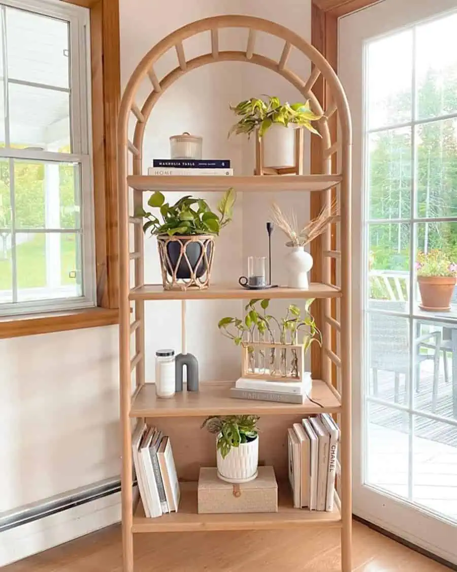 Boho-chic bookshelf with wooden arch design, decorative plants, and modern minimalist decor.