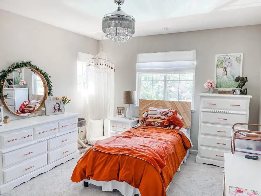 Boho chic orange bedroom with textured bedding, white furniture, natural accents, and cozy decor.