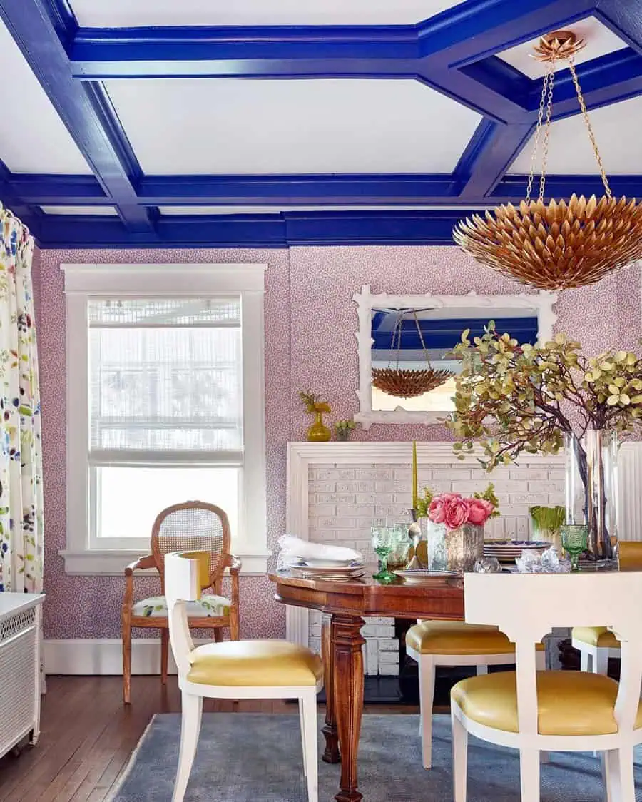 Vibrant dining room with a bold blue coffered ceiling, eclectic decor, and a statement chandelier.