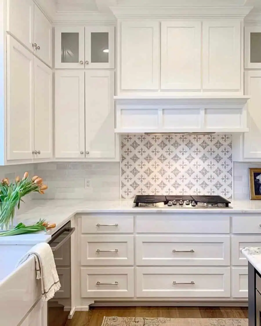 Bold patterned backsplash adds contrast and character to white cabinets for a striking kitchen design.