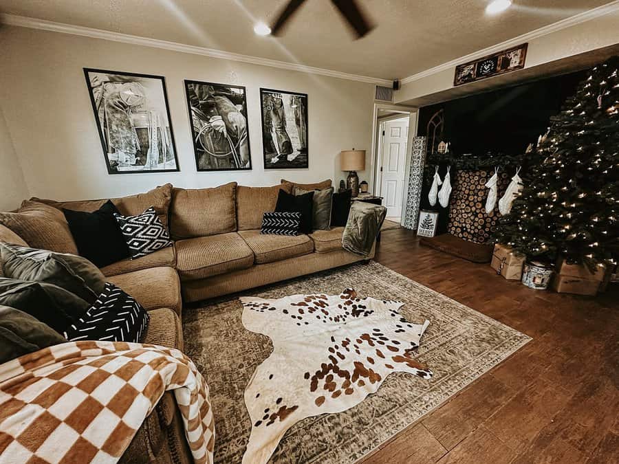 Cozy carpeted living room with a brown sectional, cowhide rug, and festive holiday decor.