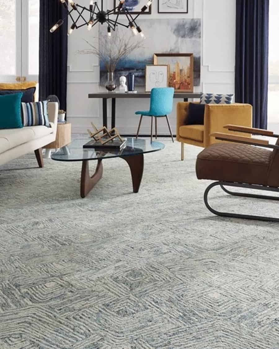 Carpeted living room with a modern design, glass coffee table, and colorful accent chairs.