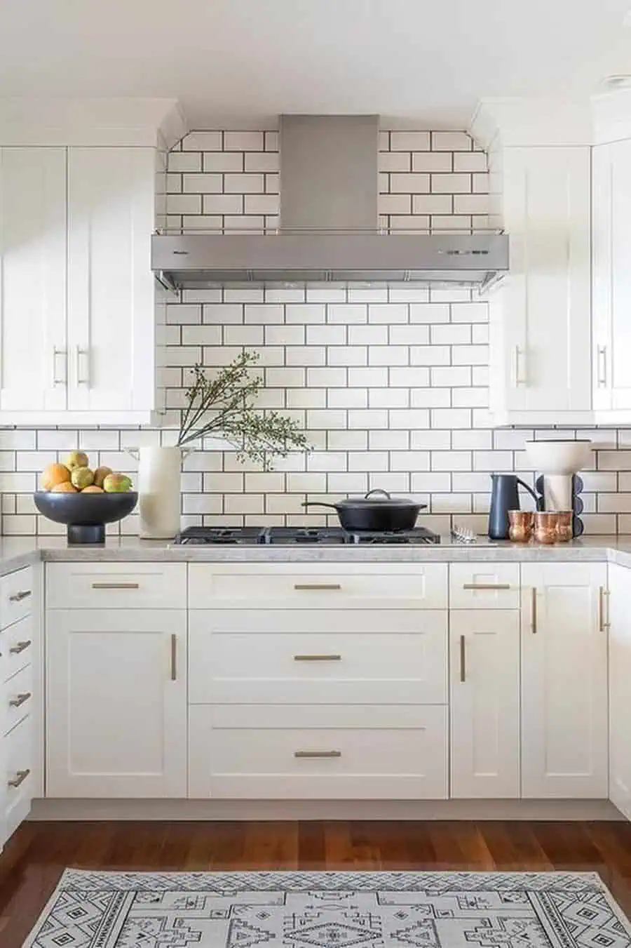 Classic white subway tile backsplash with dark grout adds contrast and timeless elegance to white cabinets.