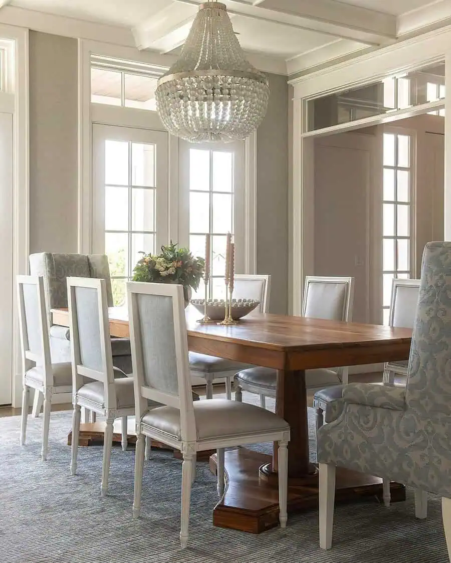 Elegant dining room with a modern coffered ceiling, wooden table, upholstered chairs, and a chandelier.