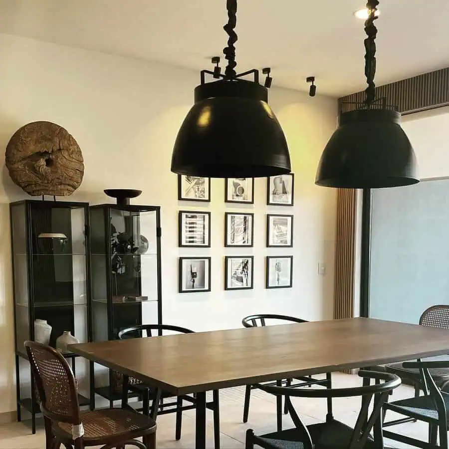 Modern dining space with bold black accents, mixed wood tones, and sleek industrial lighting.