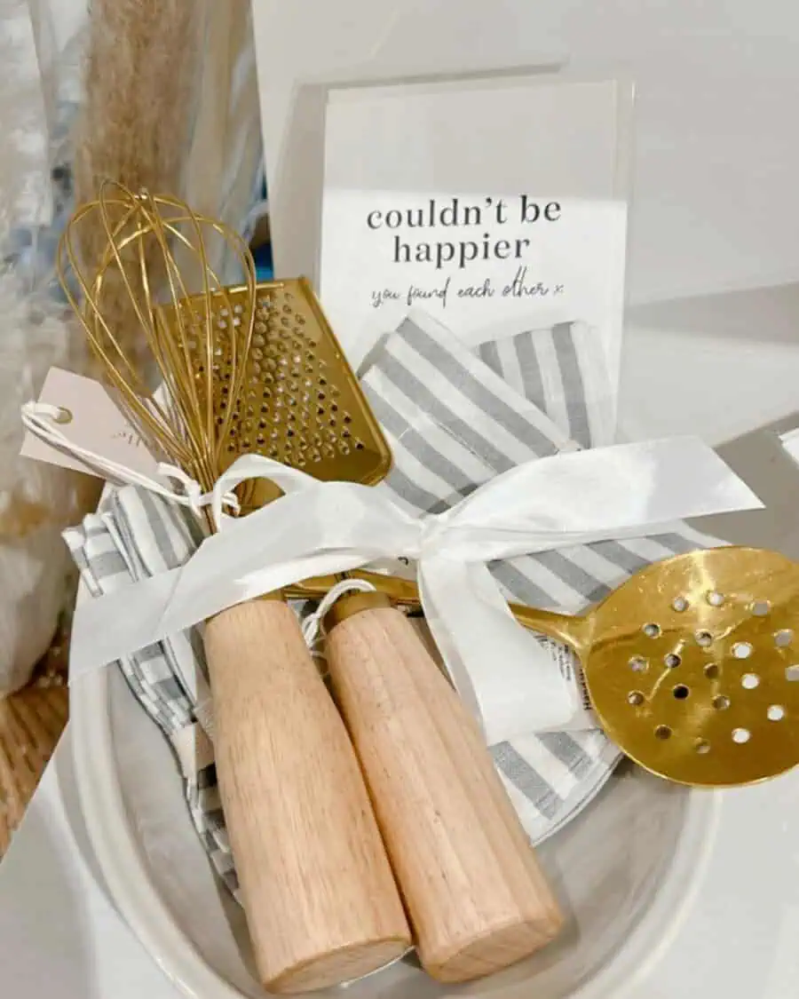 Elegant housewarming gift basket with kitchen essentials, gold utensils, and a heartfelt message.