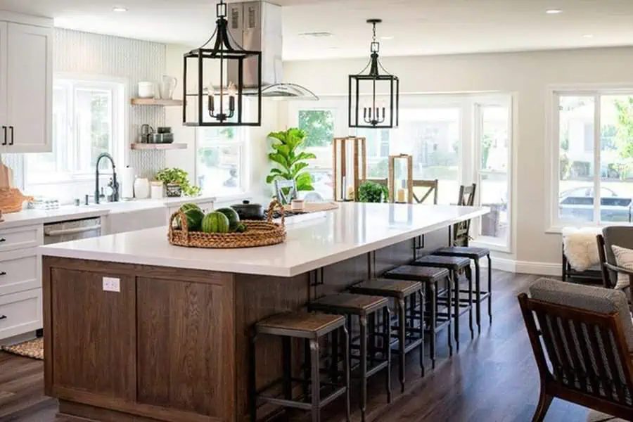 Family-friendly open kitchen with a large island, dark wood base, and black pendant lighting.