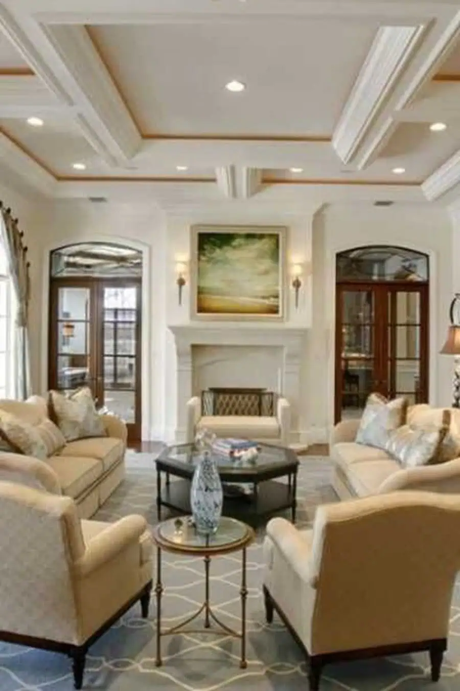 Elegant family room with a modern coffered ceiling, neutral-toned furniture, and a classic fireplace.