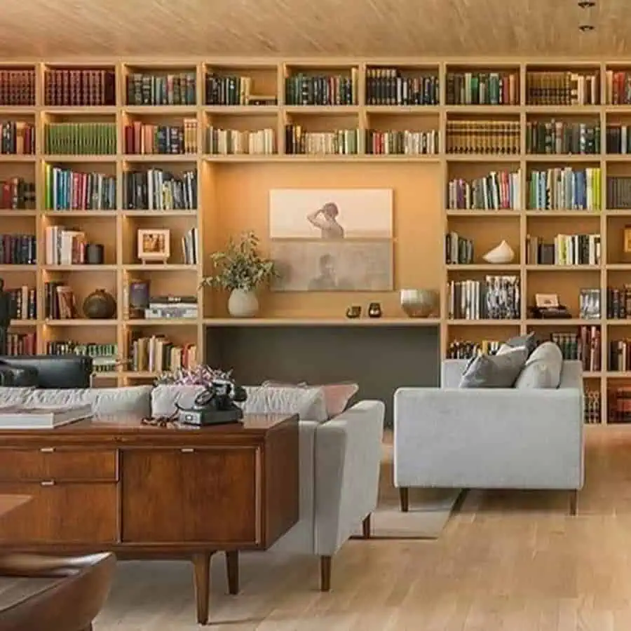 Warm and inviting living room with a floor-to-ceiling wooden bookshelf and cozy seating area.