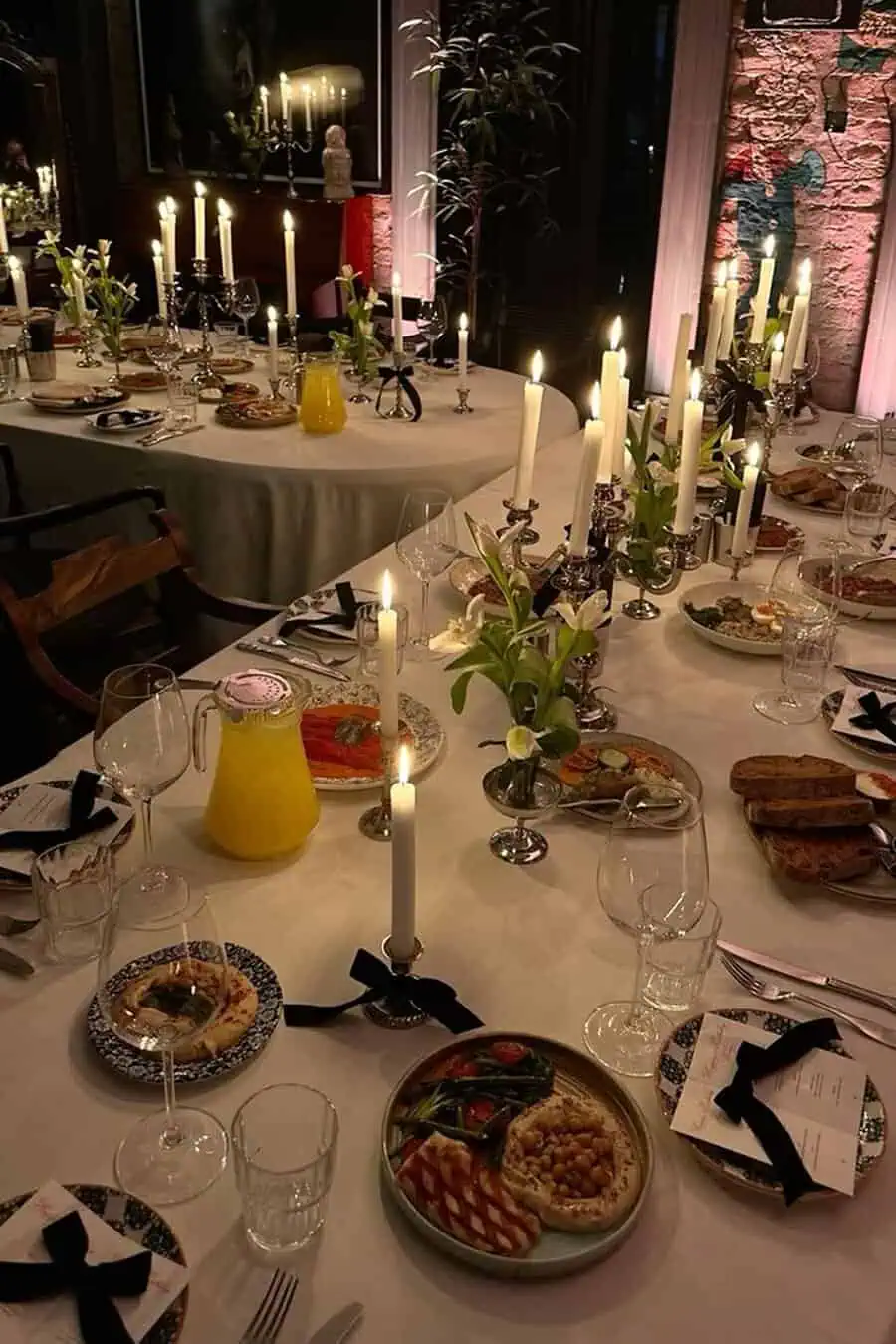 Formal dinner vibes at a housewarming party with candlelit tables, elegant plating, and sophisticated decor.