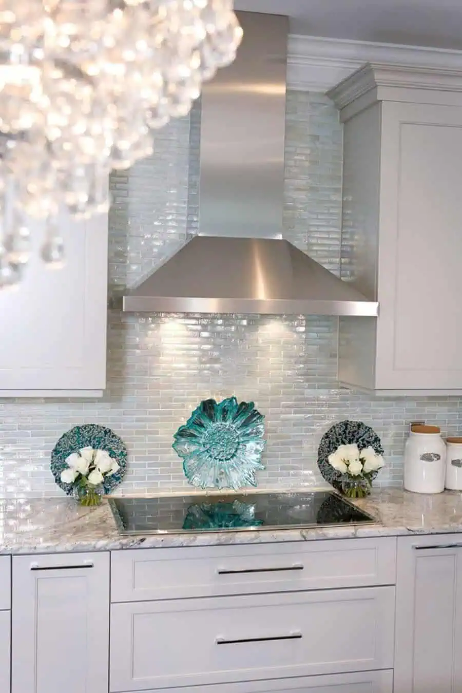 Glossy ceramic tile backsplash complements white cabinets for a timeless and elegant kitchen look.