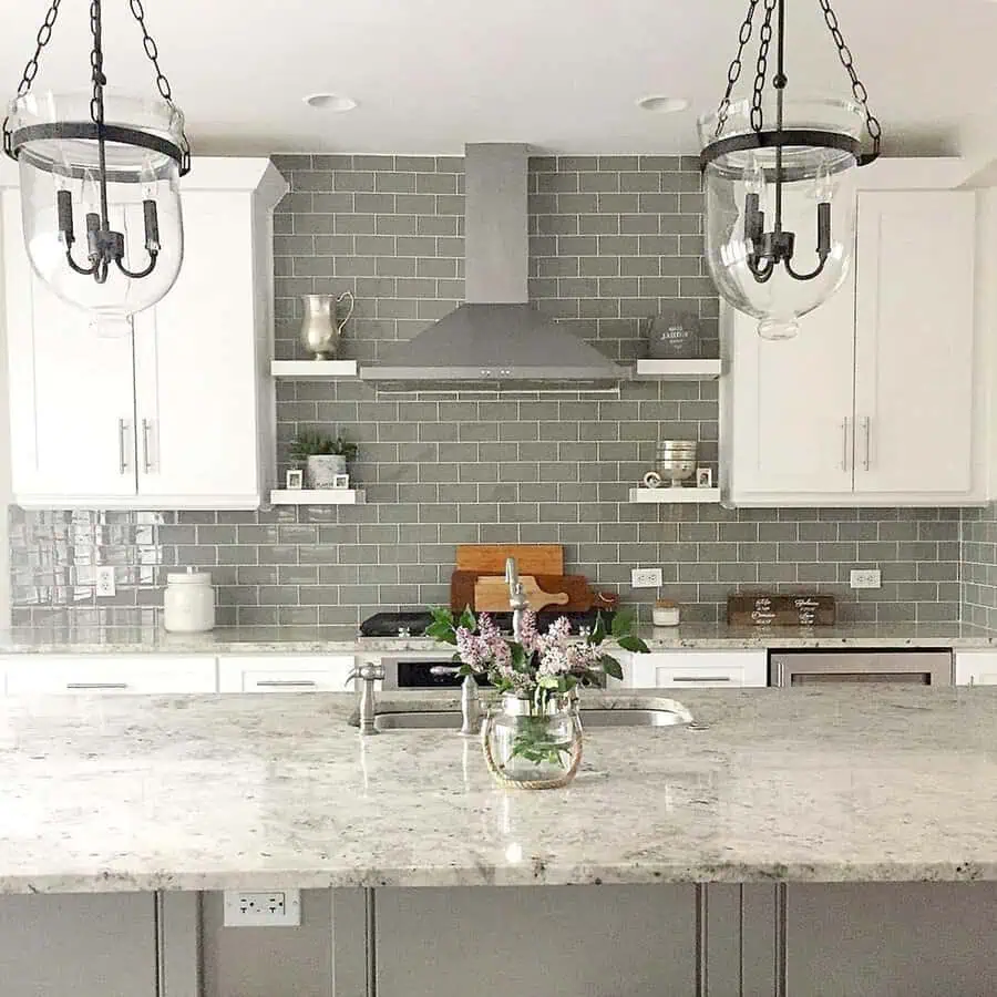 Glossy gray subway tile backsplash adds contrast to white cabinets for a timeless and elegant kitchen.