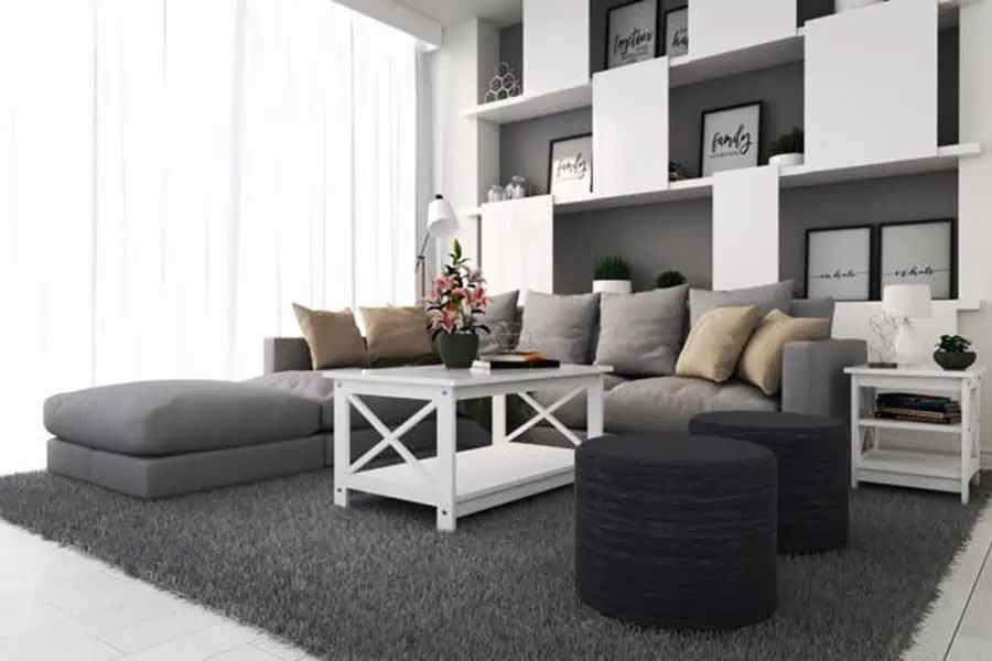 Grey and white living room with a sectional sofa, built-in shelving, and modern decorative accents.