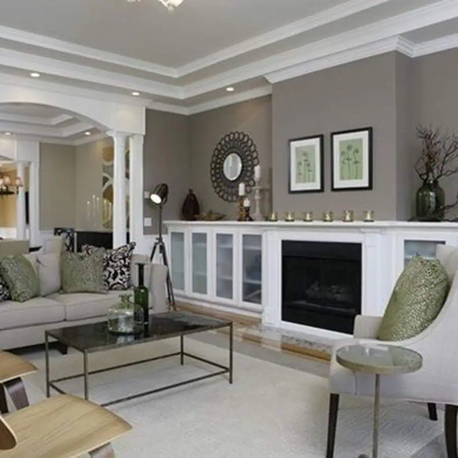 Grey and white living room with a fireplace, modern decor, and green accent pillows.