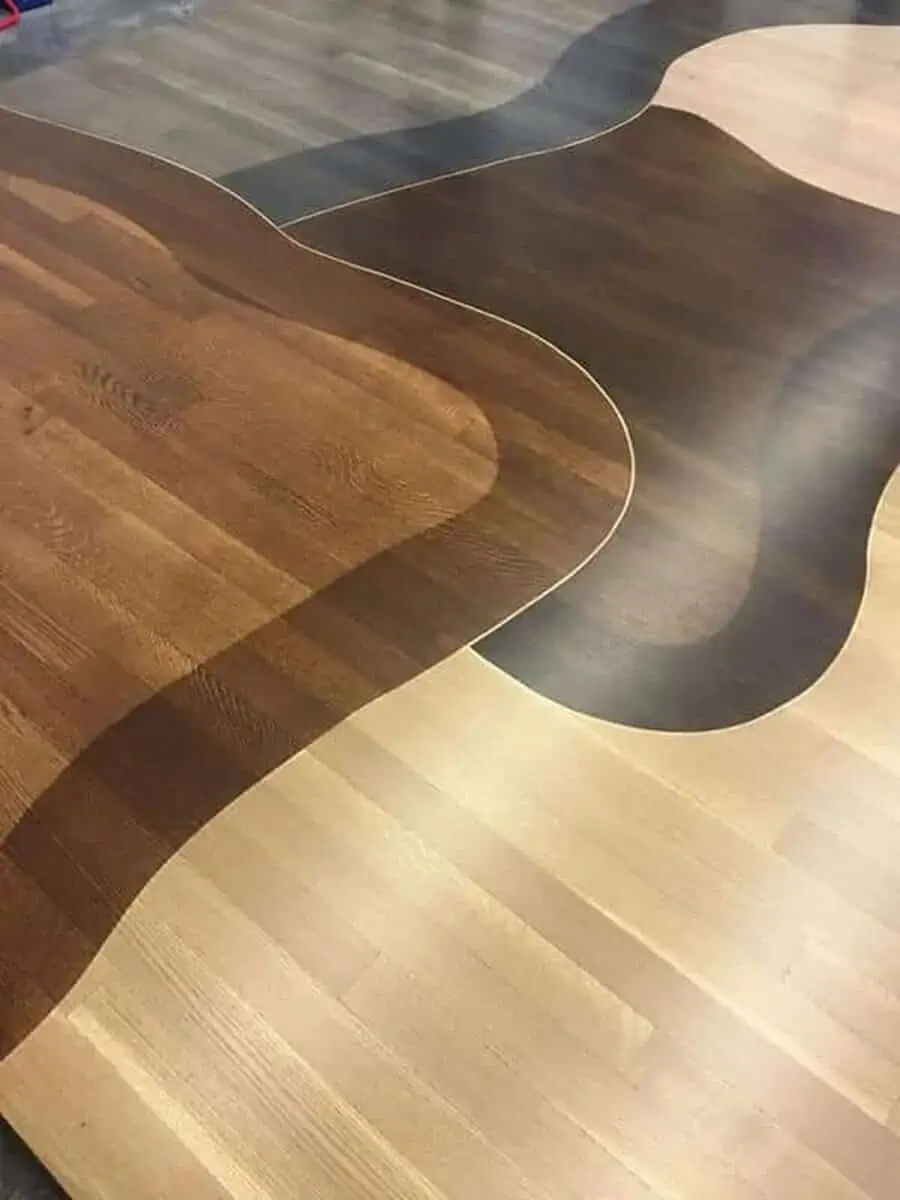 Artistic hardwood flooring design with unique wood stains creating bold contrast.