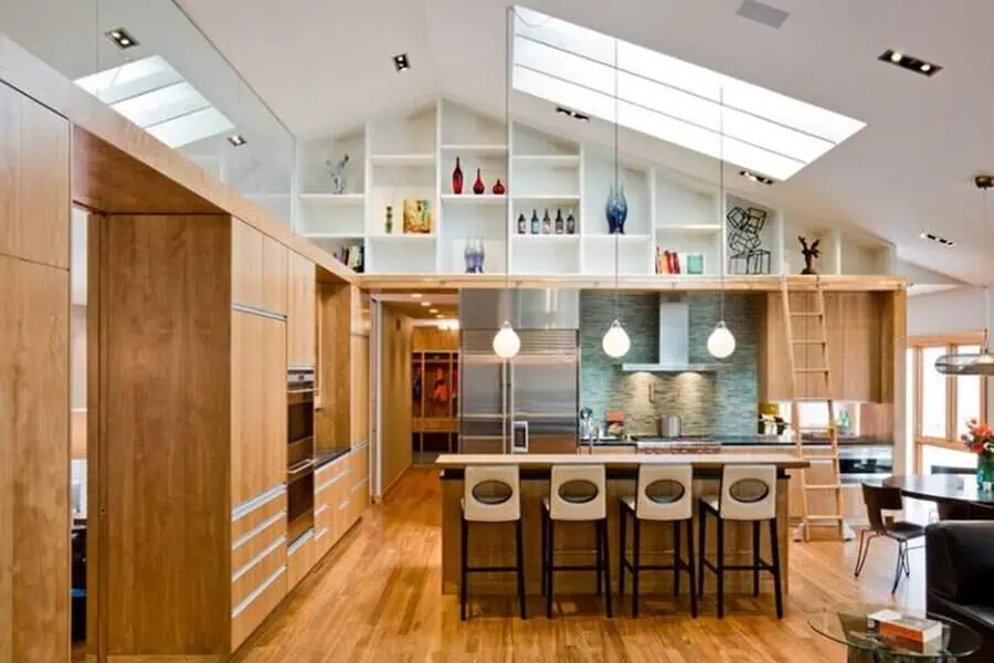 High-ceiling open kitchen with floor-to-ceiling cabinets, skylights, and a stylish bar seating area.