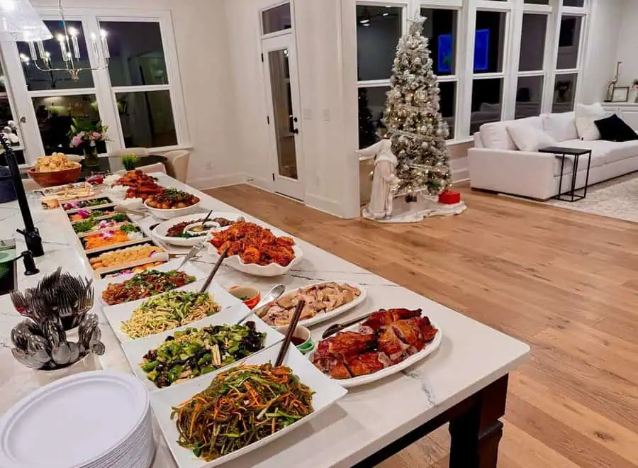 Holiday-themed housewarming party with a buffet spread, elegant decor, and a beautifully lit Christmas tree.