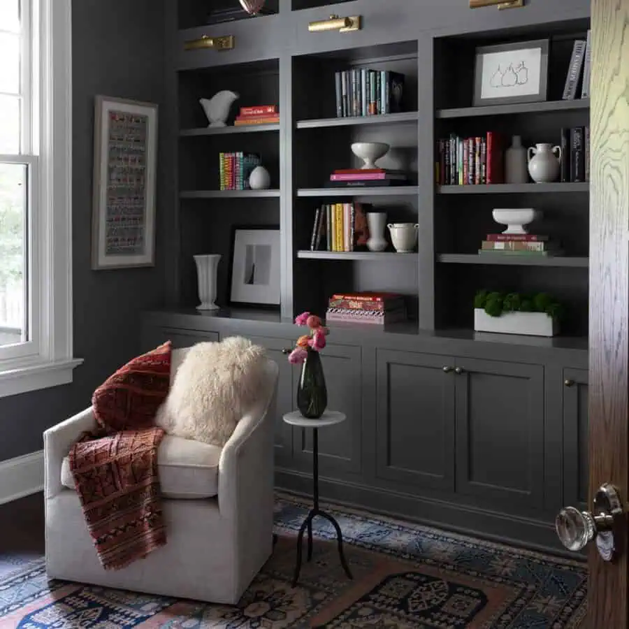 Home library with dark statement bookshelves, cozy seating, and elegant decor accents.