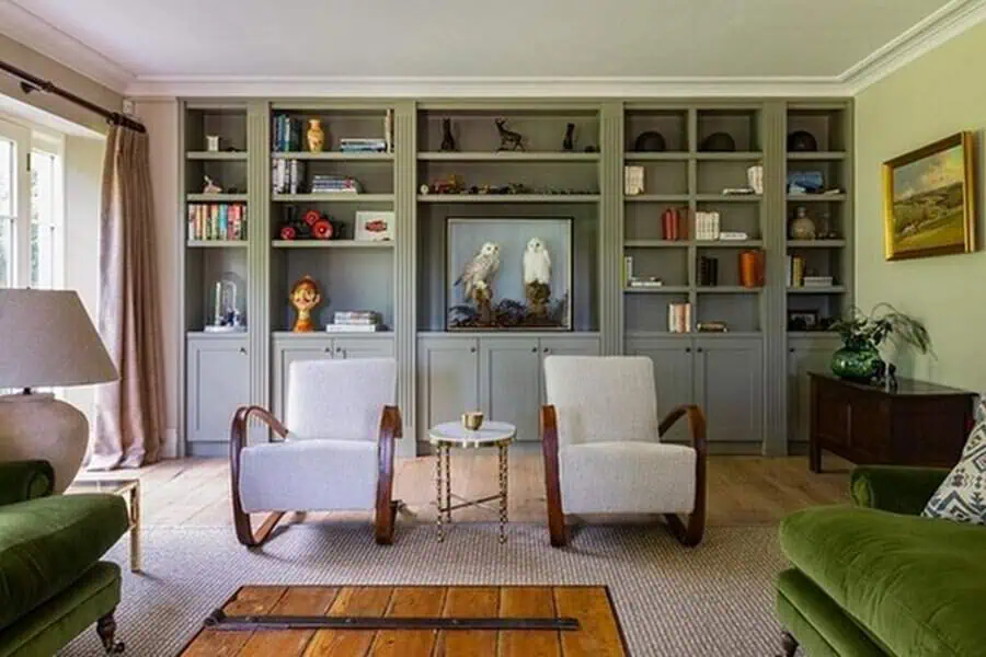 Home library with built-in bookshelves, cozy armchairs, and a well-curated furniture setup.