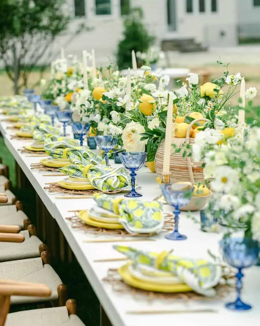 Housewarming spring garden party with a beautifully decorated table, fresh lemons, flowers, and candles.