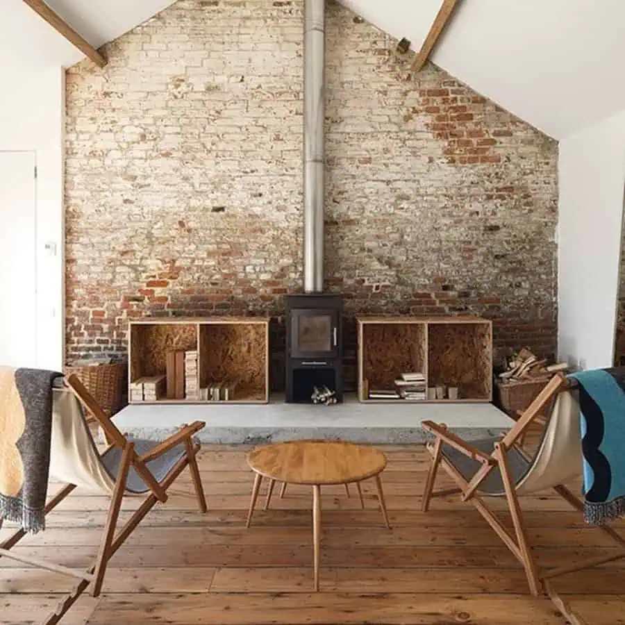 Industrial vibes with warm touches, featuring mixed wood tones, exposed brick, and a cozy stove.