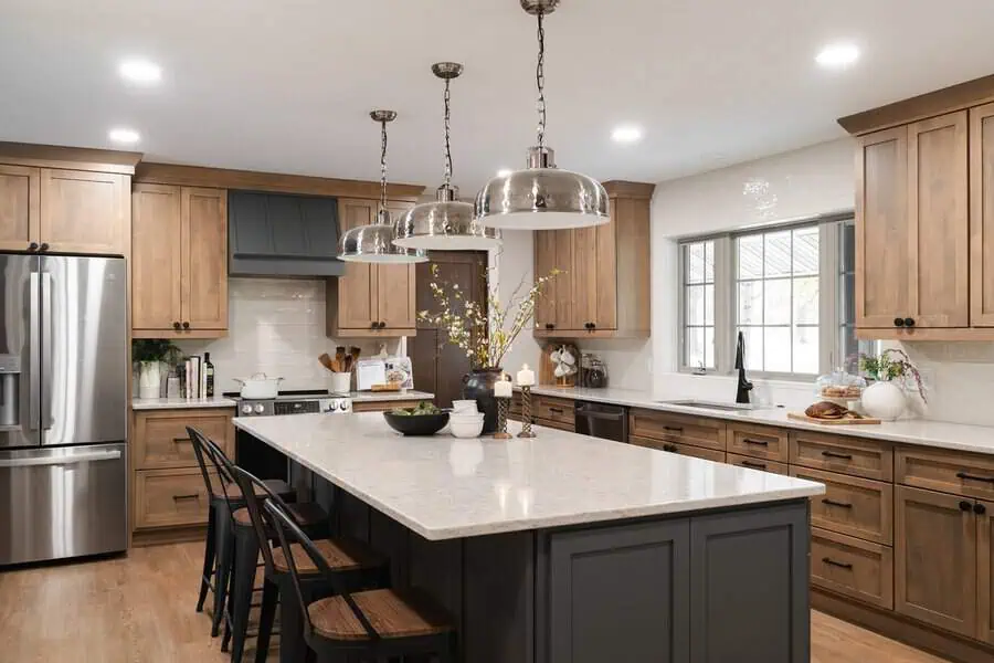 Kitchen mixing wood with metal for bold interiors, featuring warm wood cabinetry, black accents, and industrial lighting.