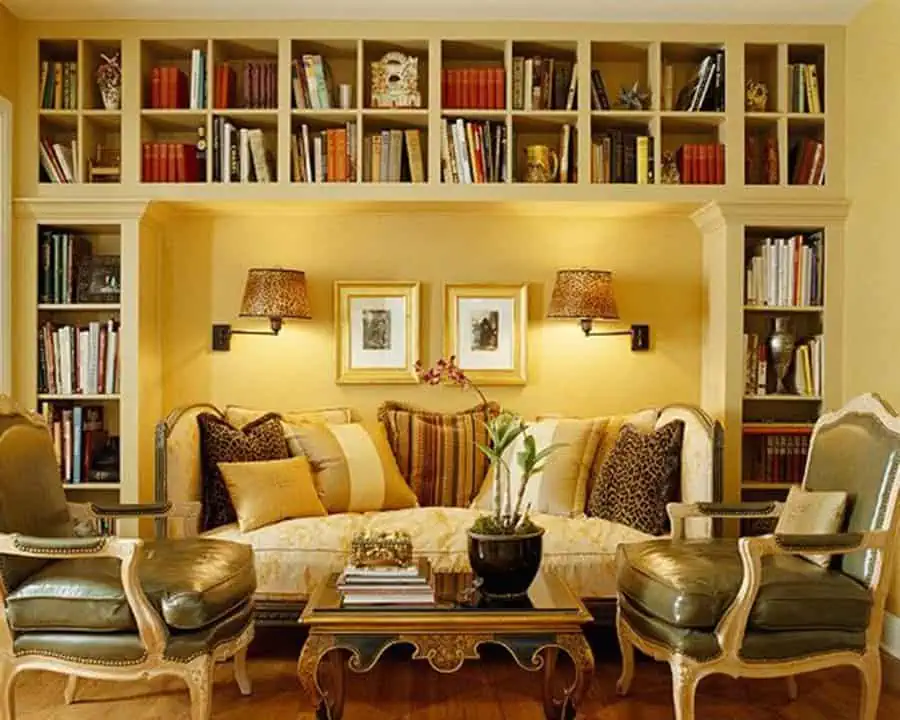 Elegant living room with built-in bookshelves, warm yellow tones, and classic vintage furniture.