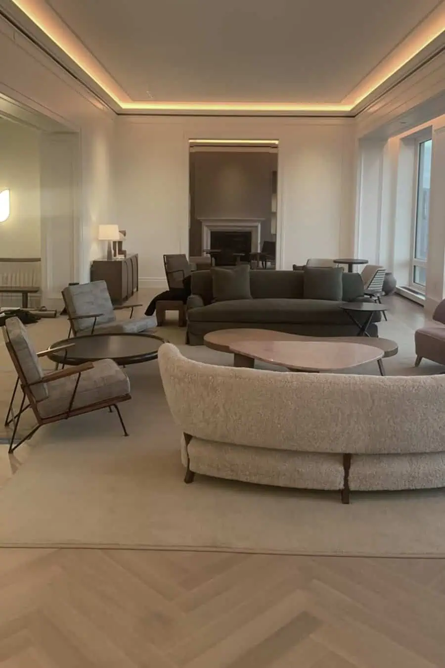 Modern living room with a sleek coffered ceiling, ambient lighting, plush seating, and neutral decor.