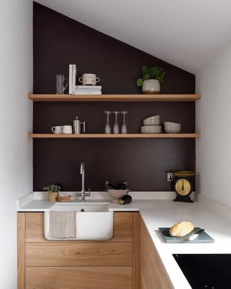 Low-budget simple kitchen design with wooden cabinets, open shelves, and a dark accent wall.