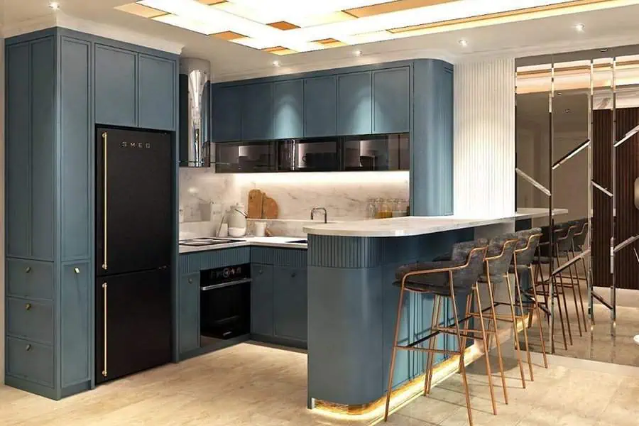 Luxurious modular kitchen with deep blue cabinets, gold accents, and a sleek breakfast bar.