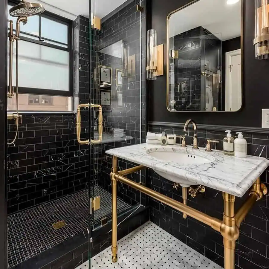 Luxury black bathroom with gold fixtures, a marble vanity, and a glass-enclosed shower.