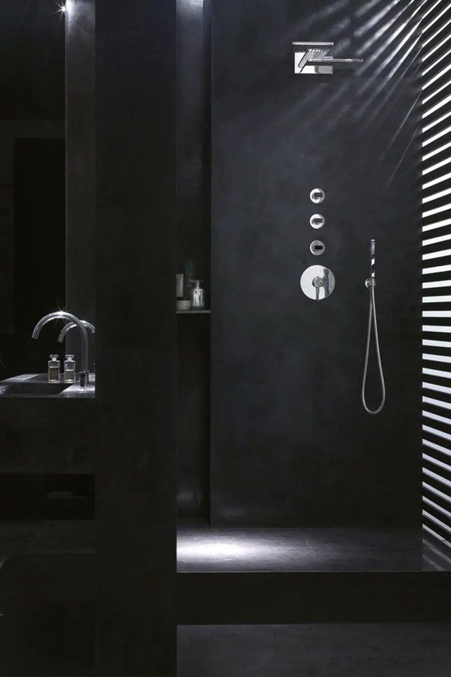 Minimalist black bathroom with a sleek walk-in shower and modern chrome fixtures.