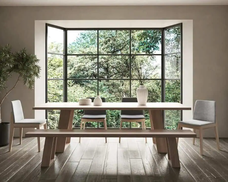 Minimalist interior with light hues, mixed wood tones, sleek furniture, and a serene natural view.