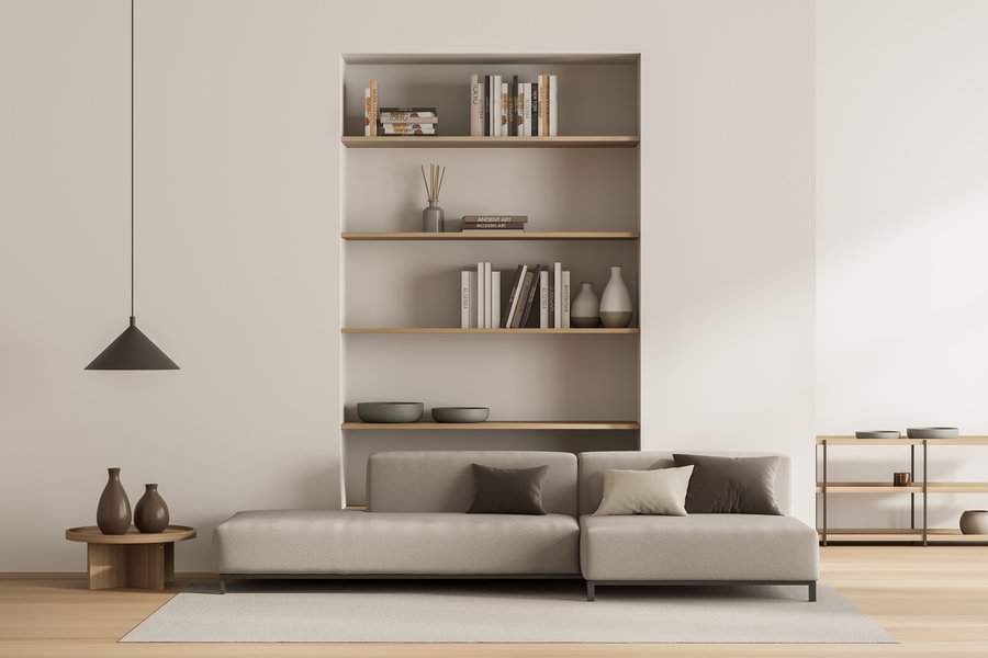 Minimalist living room with neutral sofa, built-in bookshelf, and modern decor accents.