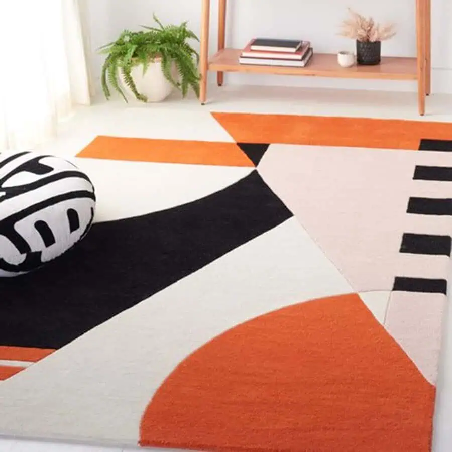 Modern bedroom rug with bold geometric patterns in orange, black, and beige for a stylish accent.