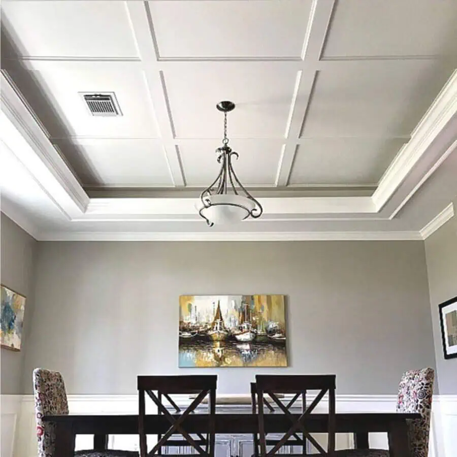 Modern dining room with a DIY coffered ceiling, elegant chandelier, and neutral-toned decor.