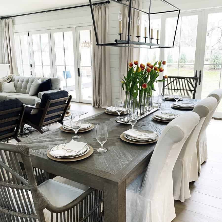 Modern Dutch Colonial dining room with a rustic wood table, elegant tulip centerpiece, and natural light.