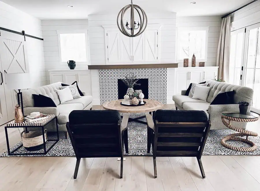 Modern Dutch Colonial living room with a black-and-white color scheme, shiplap walls, and a cozy fireplace.