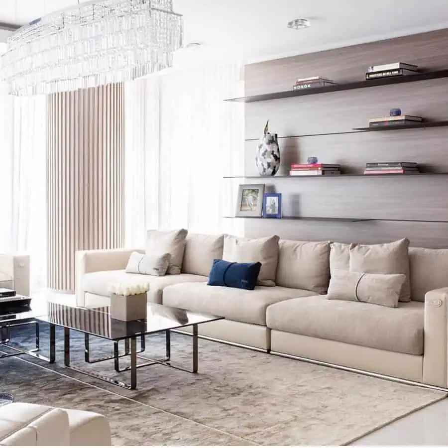 Modern living room with floating shelves, neutral-toned sofa, and a statement crystal chandelier.