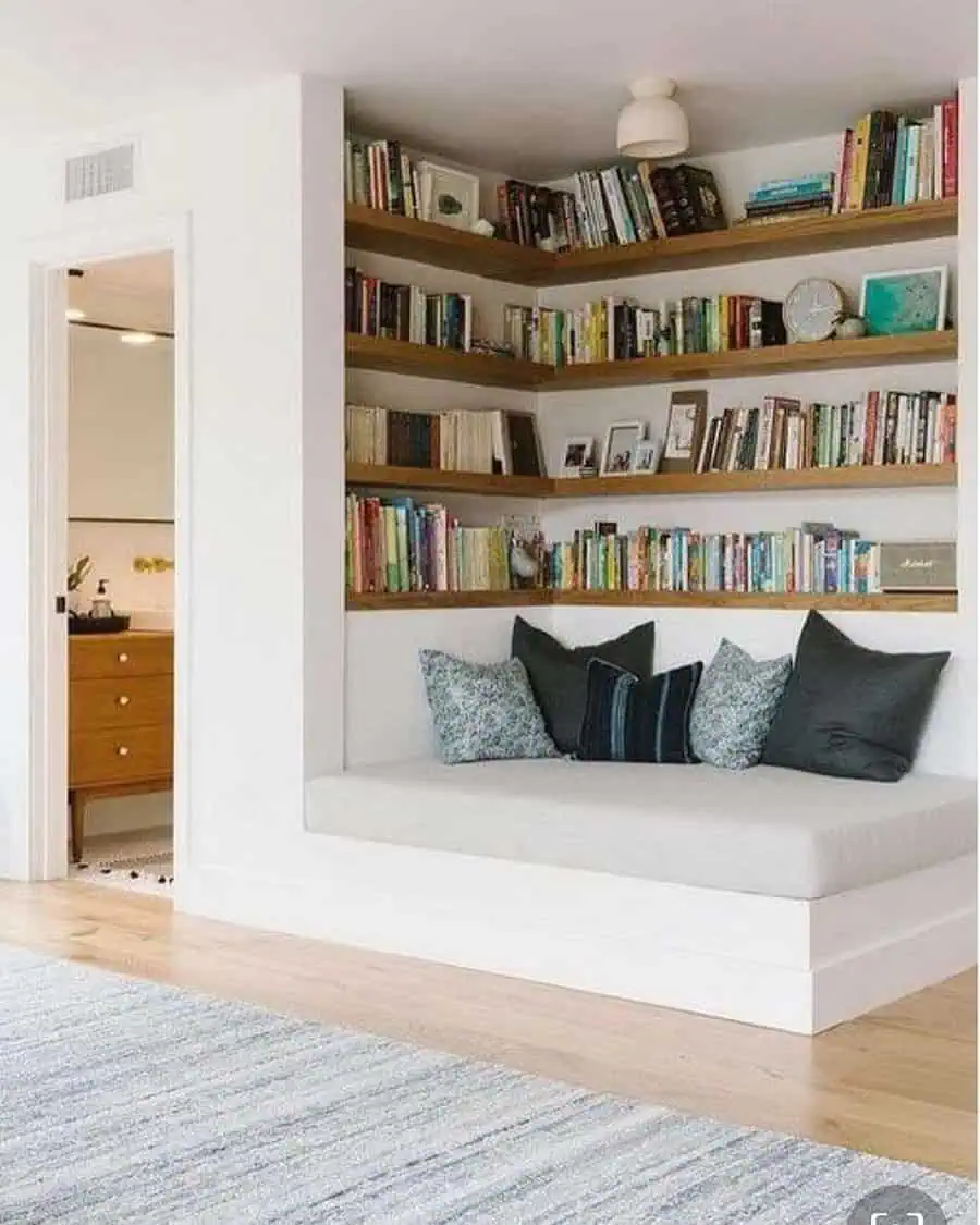 Modern home library with built-in corner bookshelves and a cozy reading nook.