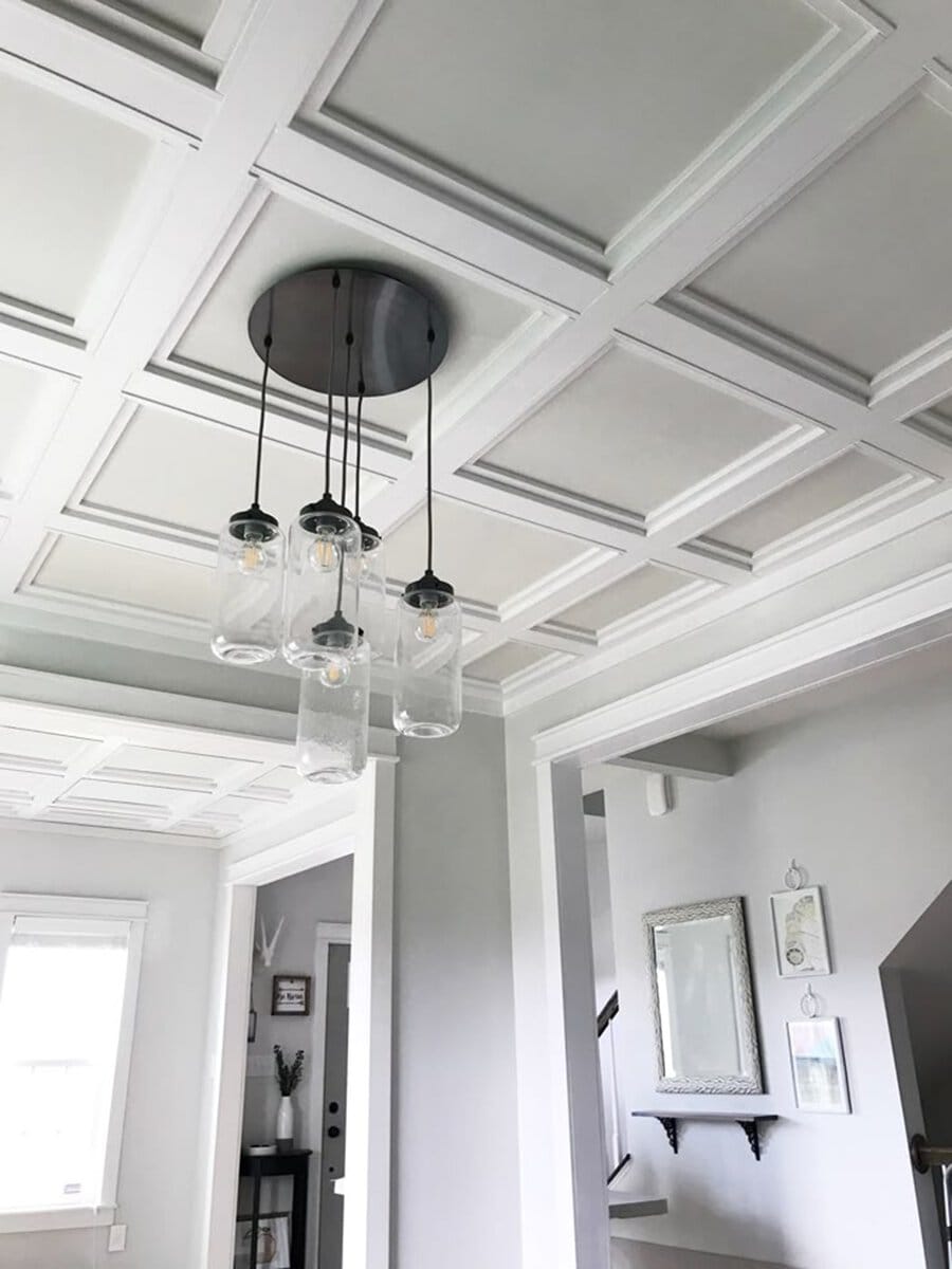 Modern interior with a DIY coffered ceiling, glass pendant lighting, and neutral-toned decor.