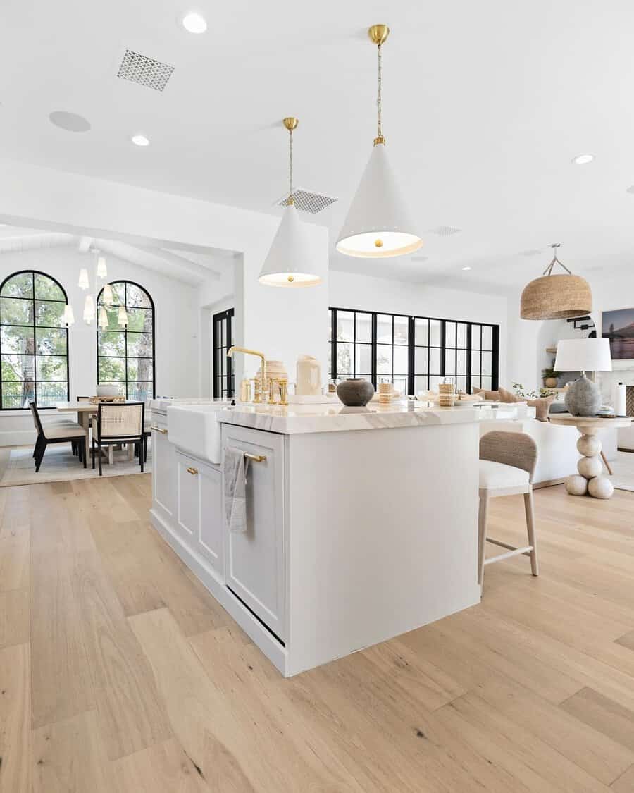 Modern minimalist open kitchen with sleek cabinetry, a marble waterfall island, and statement lighting.