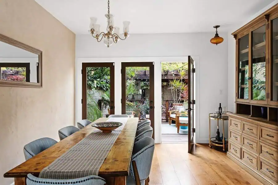 Modern two-tone Dutch Colonial interior with natural wood accents, white walls, and elegant French doors.