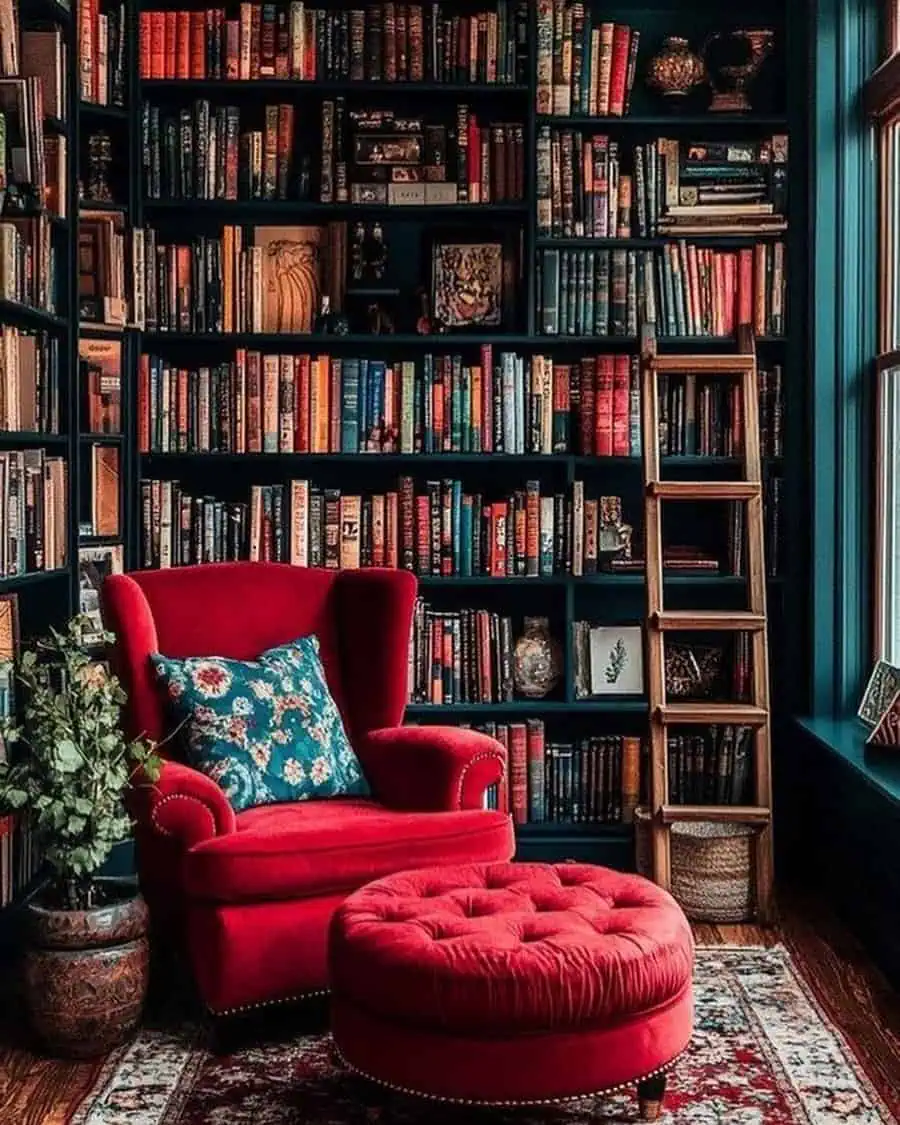 Moody home library with dark bookshelves, a red velvet armchair, and a vintage ladder.